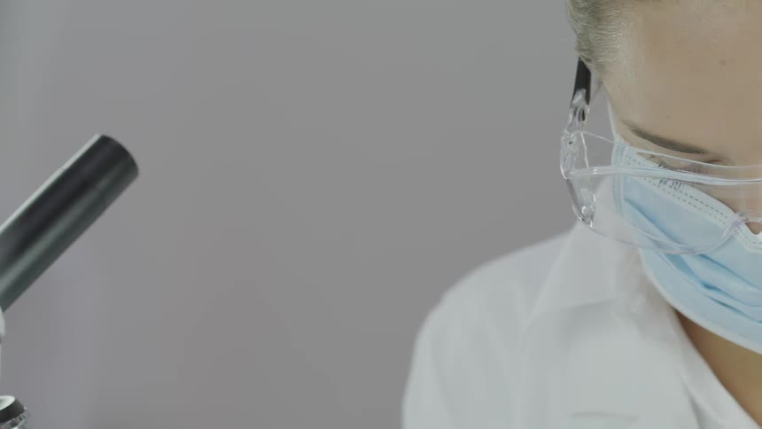 A woman with a mask and goggles looks down