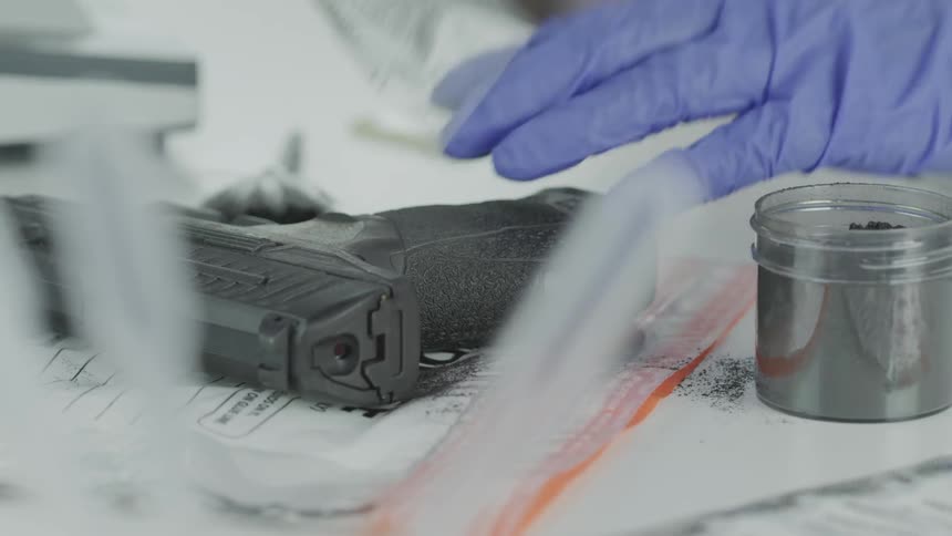 A person removes prints from a gun