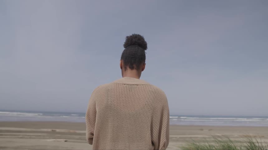A black girl stands on a beach