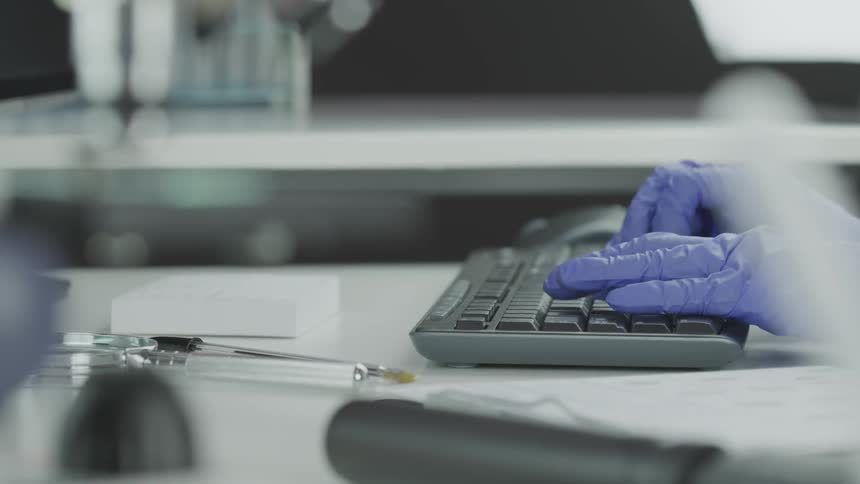 A hand typing on a computer keyboard at lab