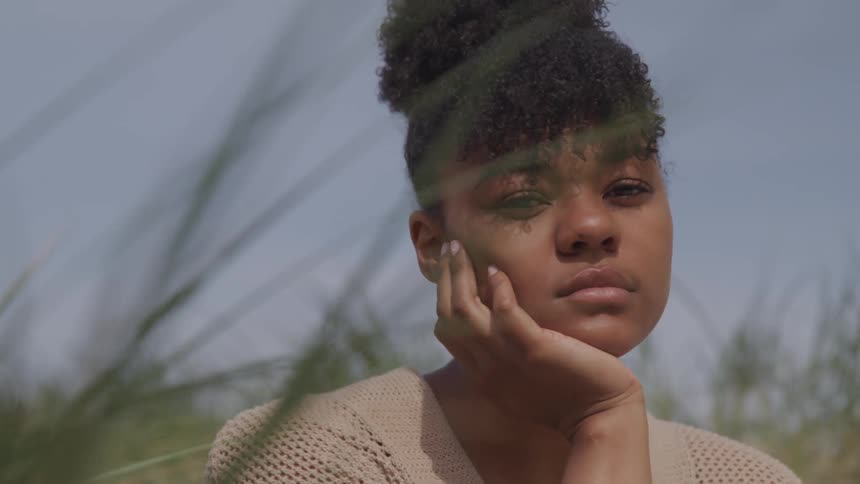 A black woman thinking in the meadow