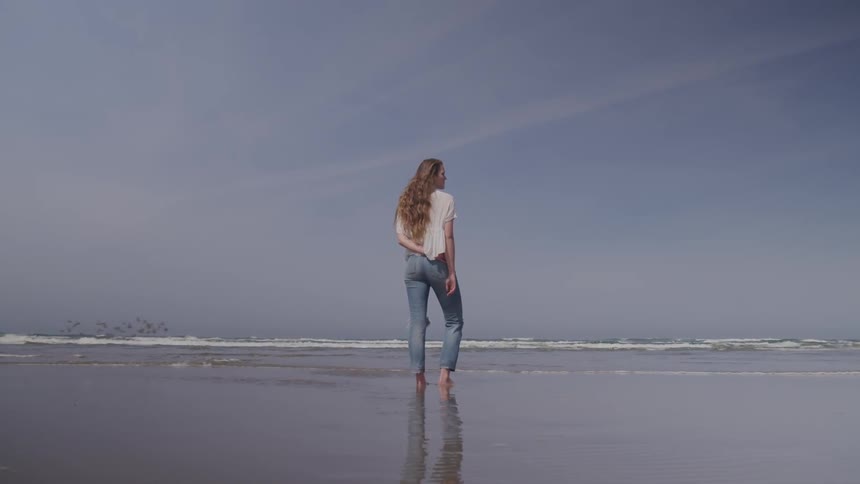 A woman stands at the beach
