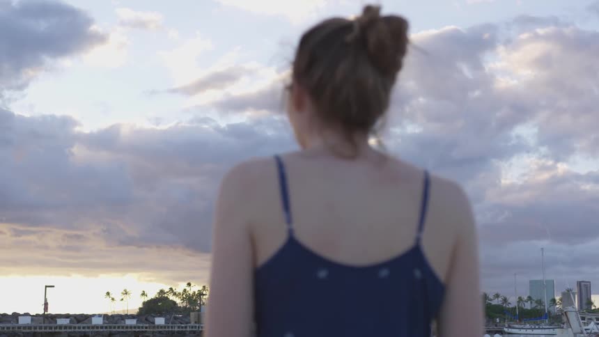 A woman stares at the skyline during sunrise