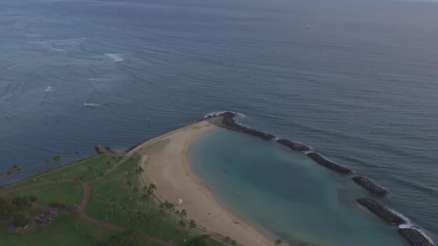 An aerial view of an ocean and beach is displayed