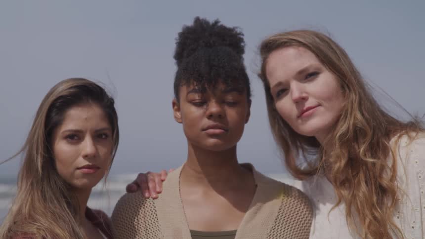 Female friends posing for the camera at the beach
