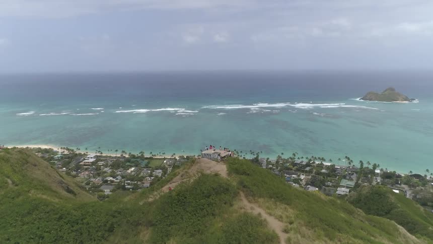 People on a hill overlooking a town and the ocean