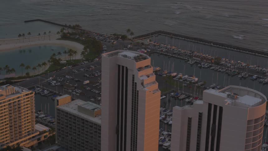 Passing over coastal high rises and boats in a marina