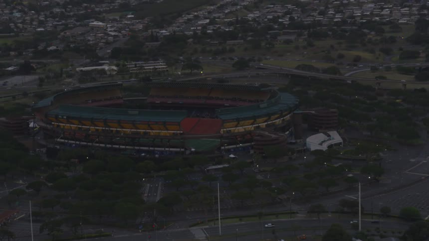 Traffic passes by a large sports facility in a city