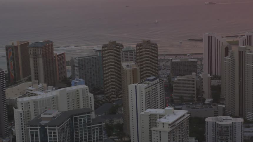 Skyscrapers and buildings in a coastal city at sunset