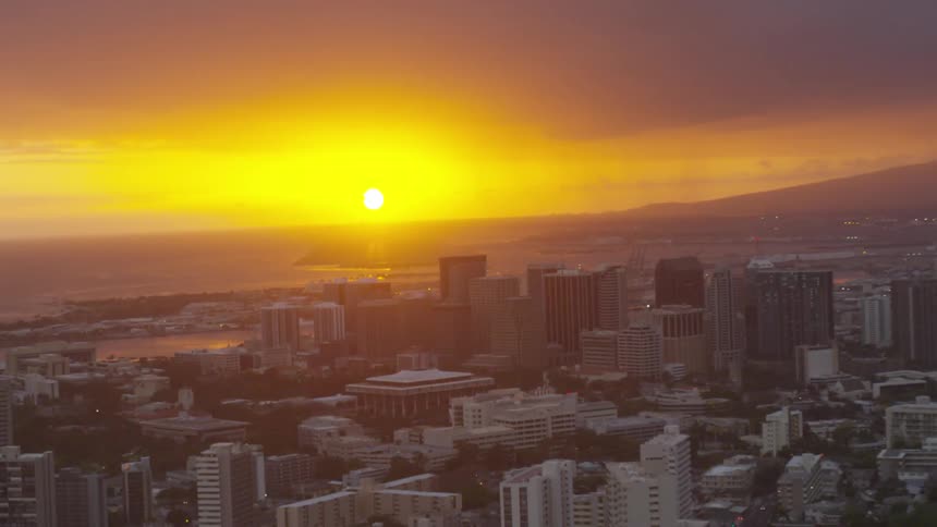 The sun is setting behind the city