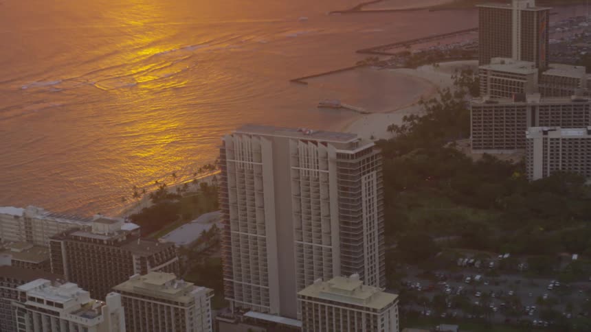 The sun is setting in the horizon of a downtown city