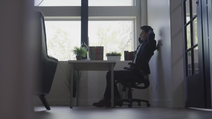 A man leans back in his chair