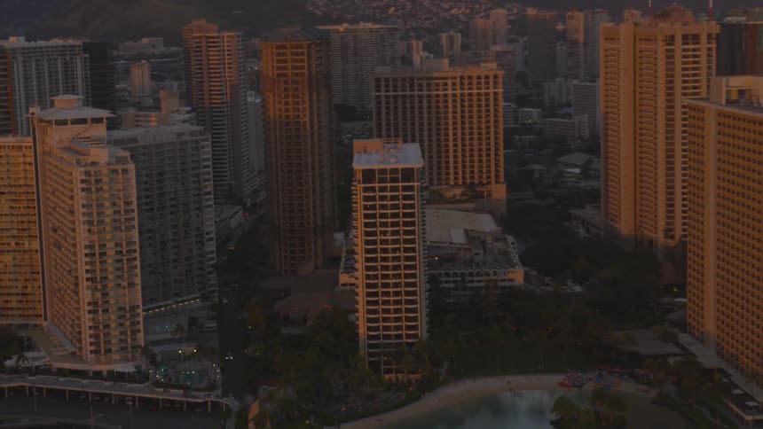 The sun shines and reflects on the skyscraper windows of a coastal city
