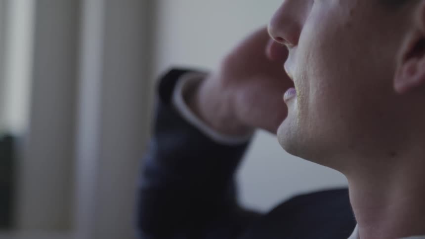 A man in an office talks on a smart phone