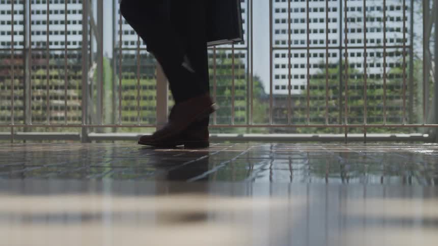 A person walking down a hallway while carrying a suitcase