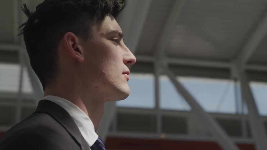 Man stands in a building and stares straight ahead