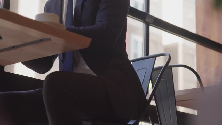 A man with blue suit sitting at the chair