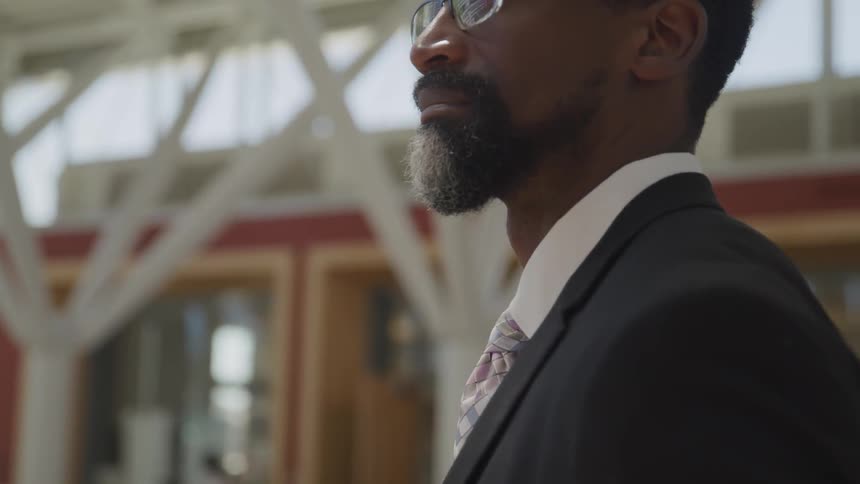 A man stands in a building wearing a suit