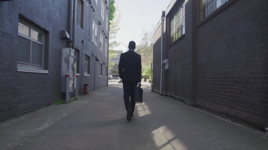 Man with suit walks in the downtown street