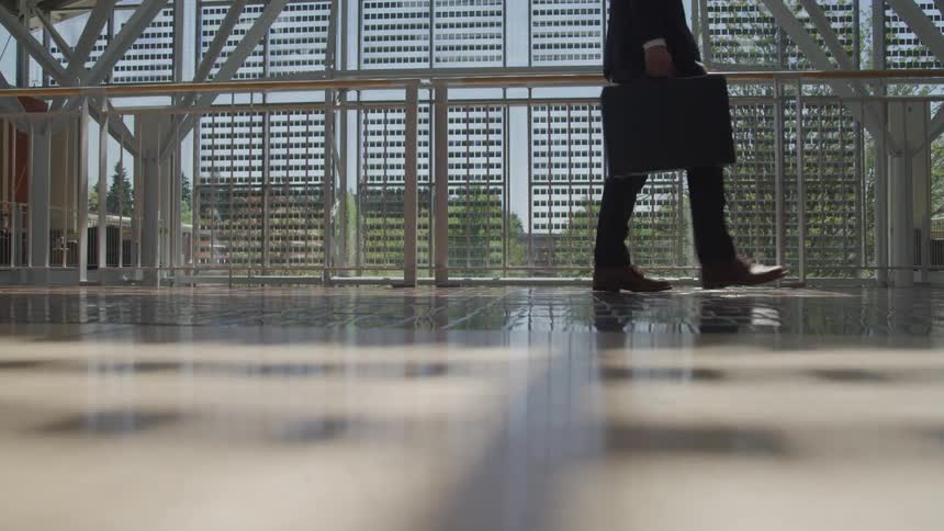 A businessman carries a briefcase as he walks through the lobby
