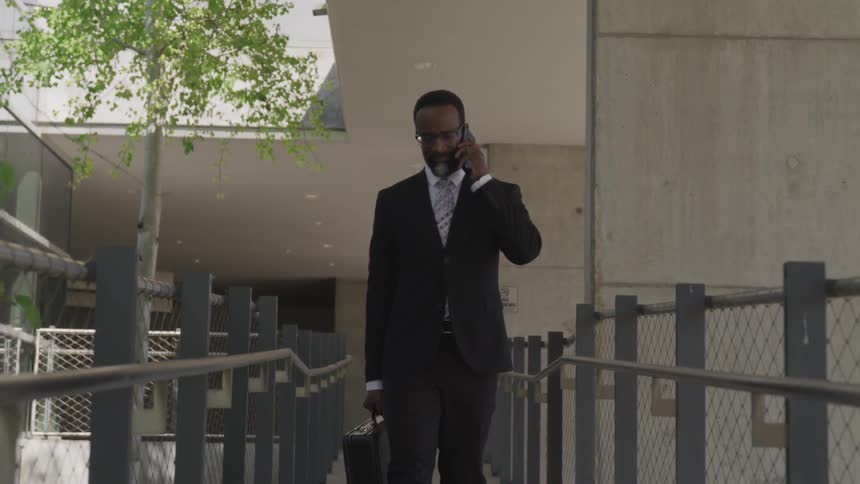 A man with suit and briefcase walks