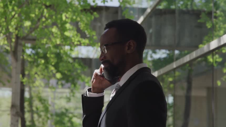 Black man with suit talks on the phone