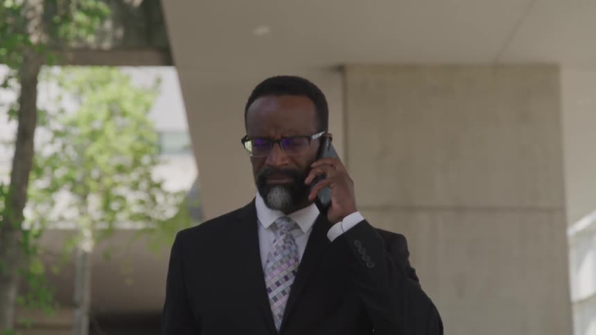 A black man talks on his cell phone