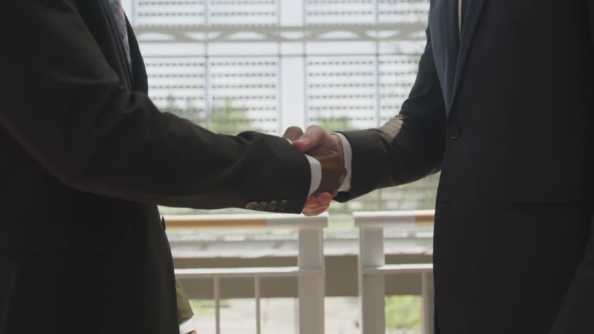 Two men in suits shaking hands