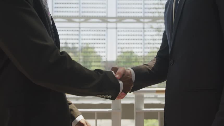 Two men shake hands