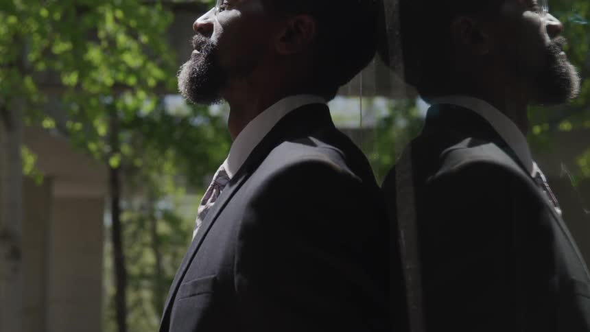 A man is standing outdoors relaxing