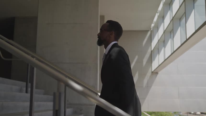 Black business man walking up stairs into an office building