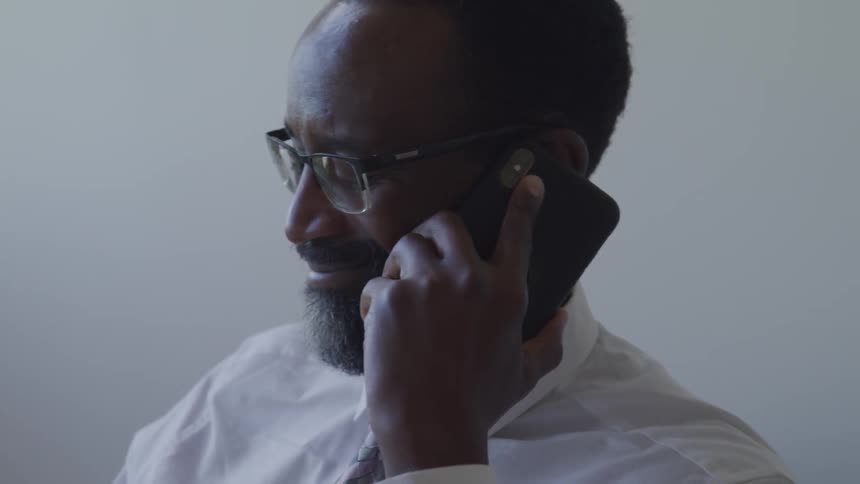 A black man talks on his cell phone