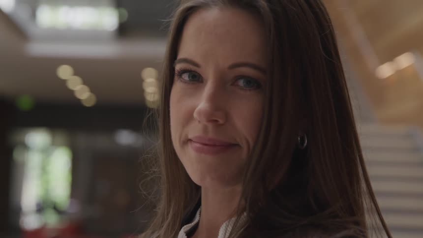 Businesswoman looks and smiles at the camera indoors