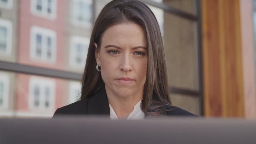 A young woman sits at her desk and works on her computer