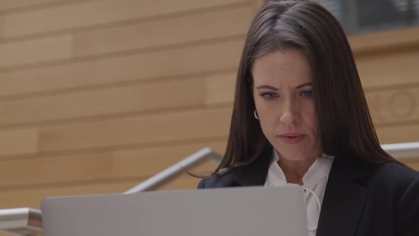 A middle aged woman working on her laptop
