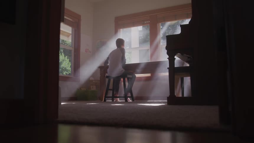 A person sits at a desk working in a room at home