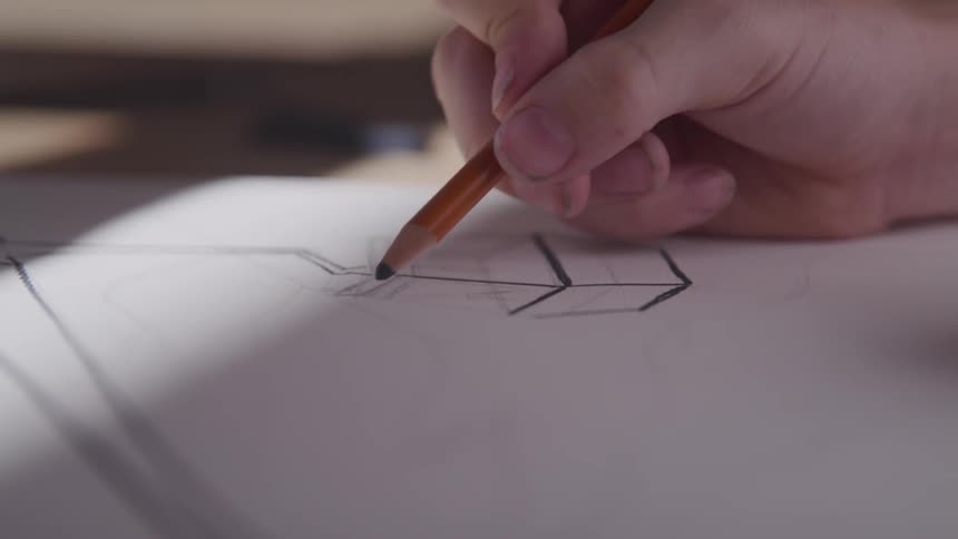 A person drawing a cube witha pencil