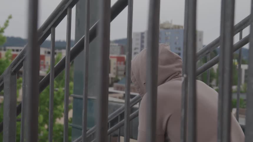 A person is sitting on the steps outside in the city