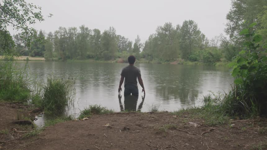 Man standing in the middle of river