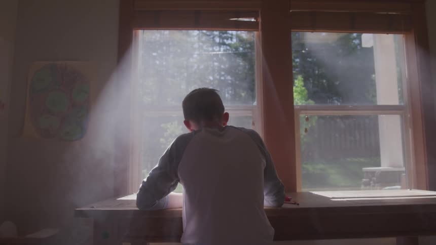 A person sitting at a desk next to a window