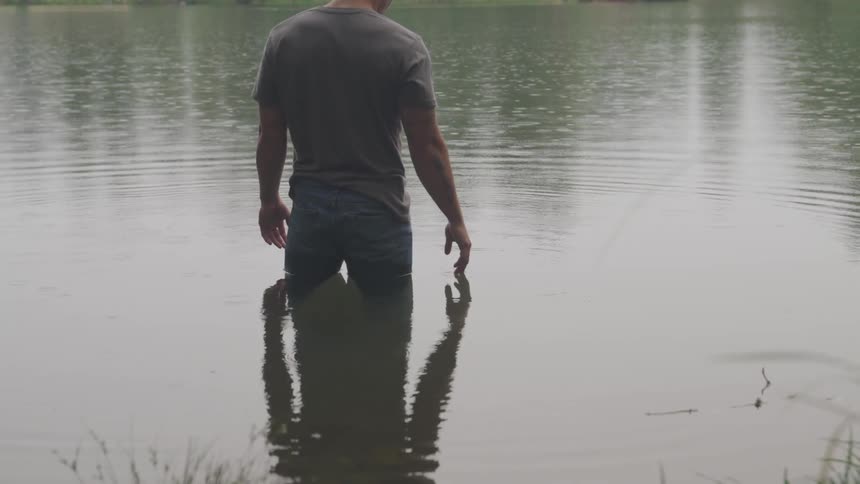 Man standing in the middle of river