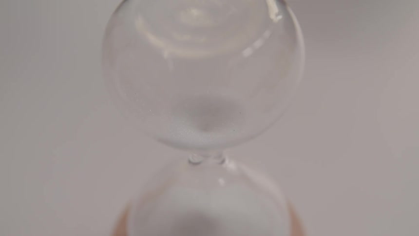 Sand is flowing through an hourglass