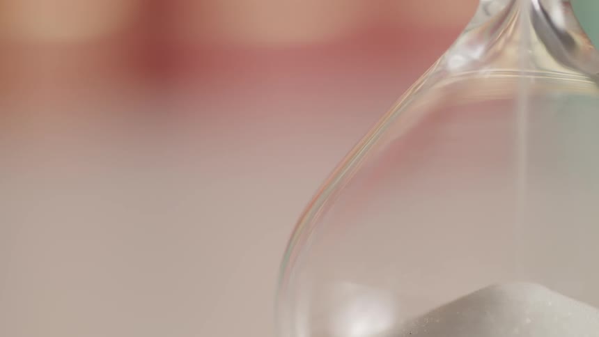 Sand is flowing into the bottom of an hourglass