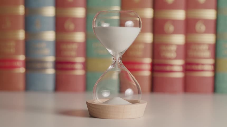 Sand moves from one end of an hourglass to the other