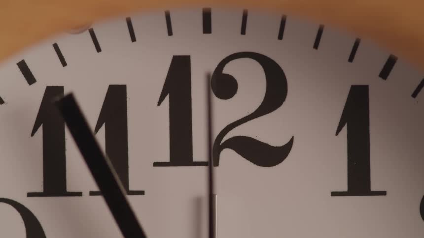 While the minute hand of a wall clock points at eleven the second hand swiftly passes by