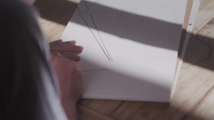 A young boy draws on paper