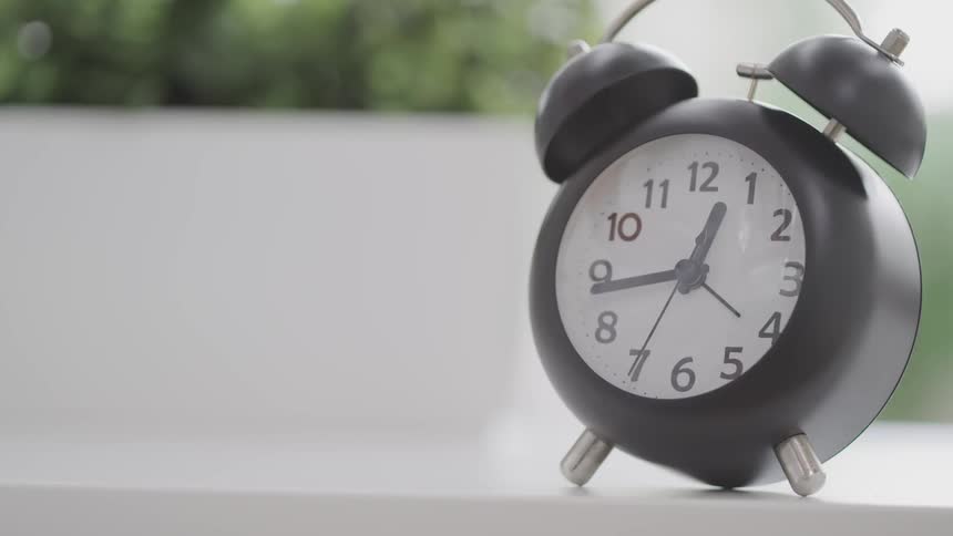 An alarm clock is almost to one oclock