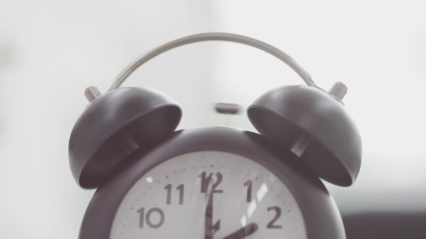 An alarm clock with bells on top is ringing