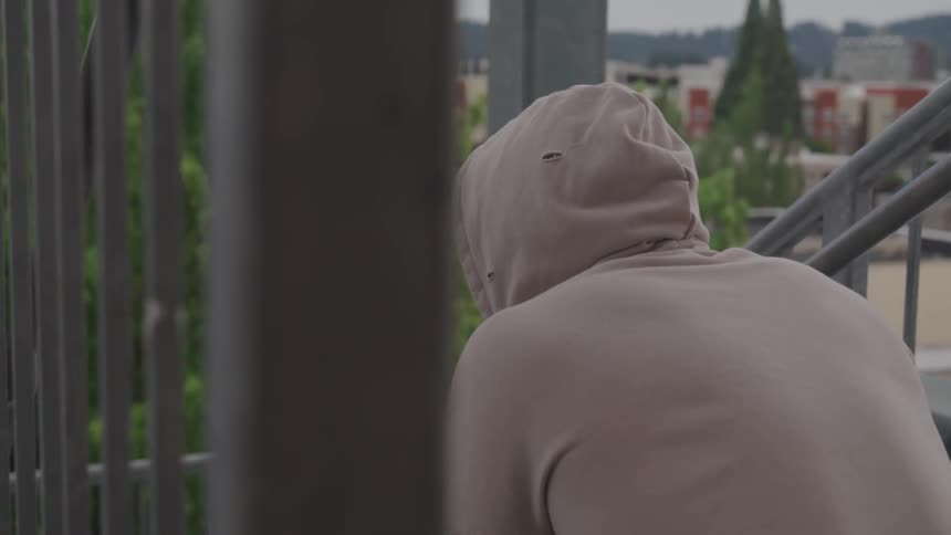 Man with white hoodie sitting on a stair