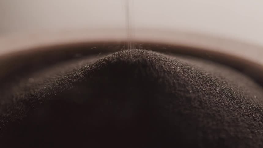 Close up of dirt being poured in to a mound